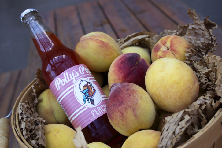 Peach flavored Polly's Pop in a basket of peaches